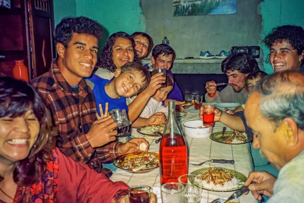 The Silveira family sitting around the dining table smiling and eating Kung Pao chicken. A Peace Corps volunteer’s story in Baltasar Brum, Uruguay.